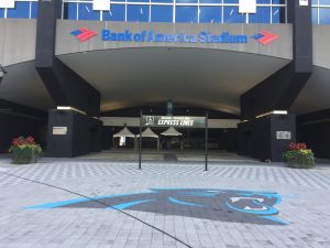 Eingang des Panthers-Stadions in Charlotte. Über dem Eingang sieht man einen großen "Bank of America" Schriftzug, auf dem Boden vor dem Eingang ist ein schwarz-blauer Panther in den Farben des Teams erkennbar.